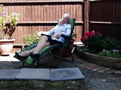 mature european lady relaxes sexily in the backyard